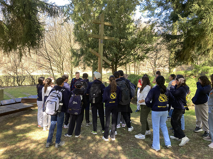 Die Schüler*innen an der Gedenkstätte im Wald bei den Massengräbern für die sowjetischen und serbischen verstorbenen Gefangenen.